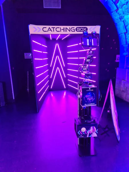 Photocall violet Catchingbox avec néons roses.