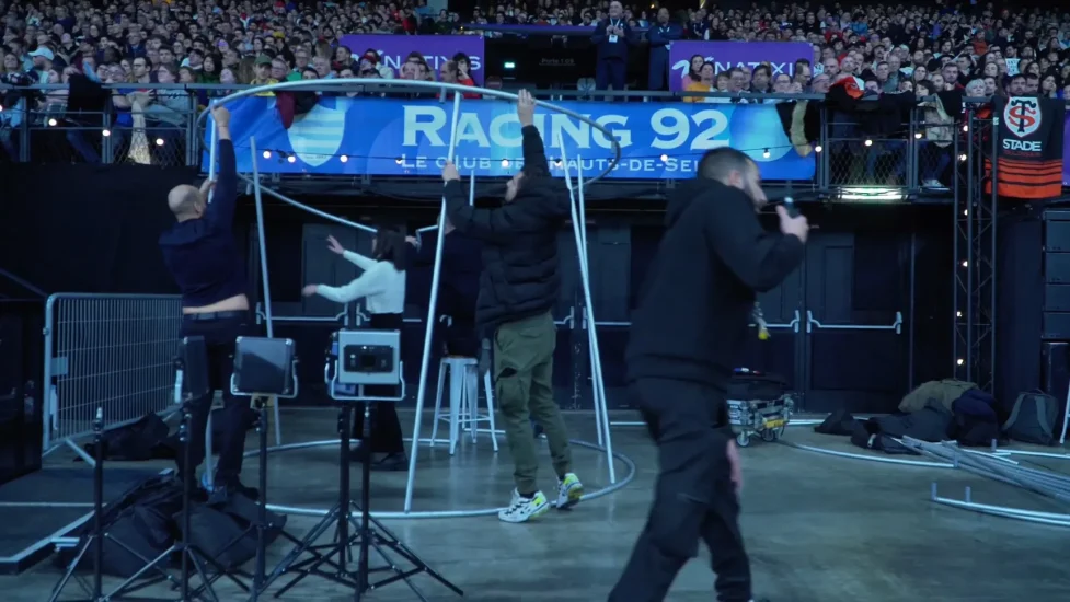 Équipe de Catchingbox installant un photocall au stade Paris la Défense Arena pour le Racing 92 devant la foule.